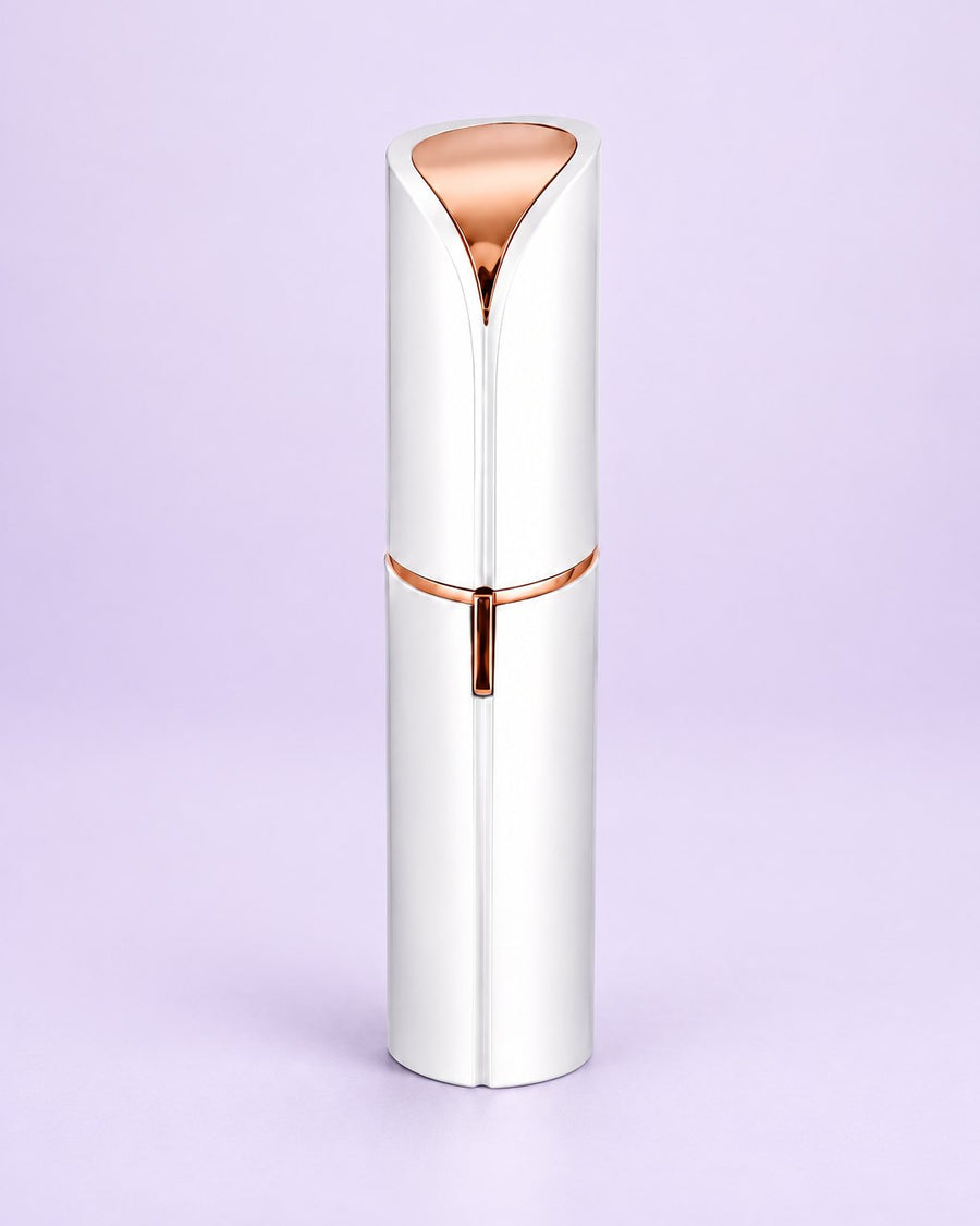White facial hair remover with its cap on, shaped like a lipstick