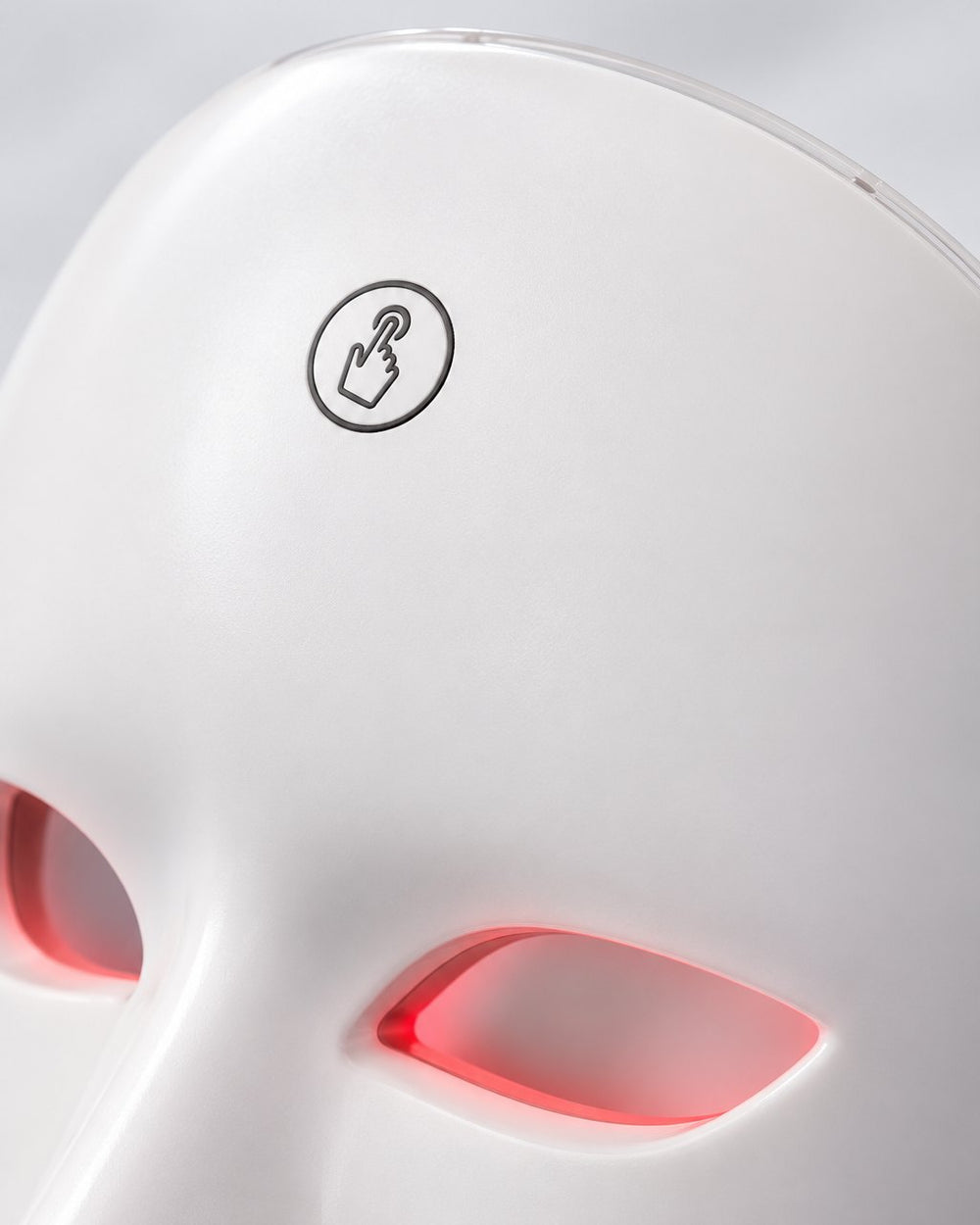 Close-up of the touch button on the forehead of the white LED face mask