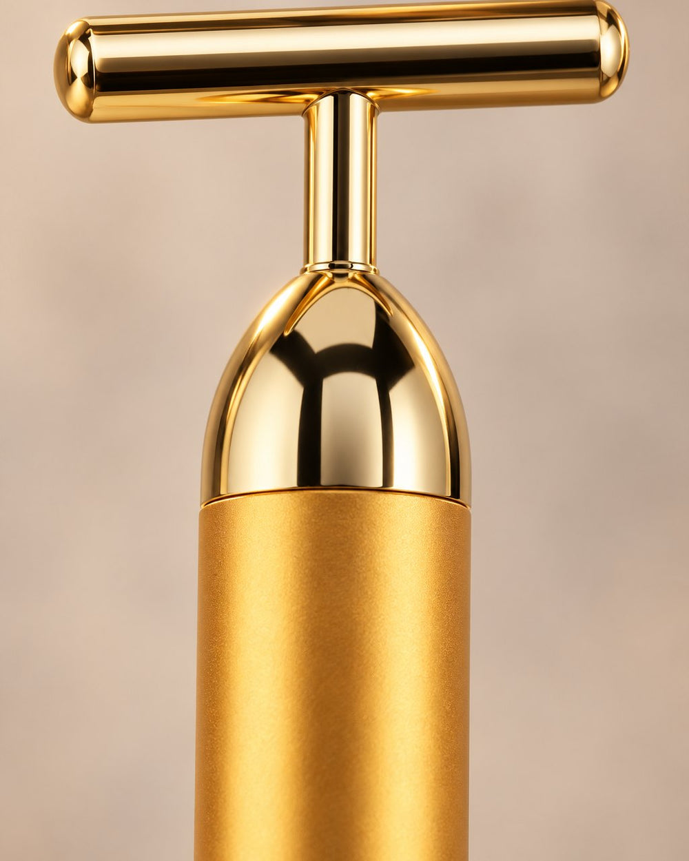 Close-up of the bar's polished gold T-head and domed top cap