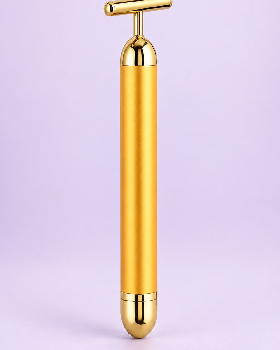Gold-tone vibrating beauty bar with a T-shaped head, standing