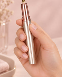 The uncapped brow trimmer held upright in one hand, slim as a pen