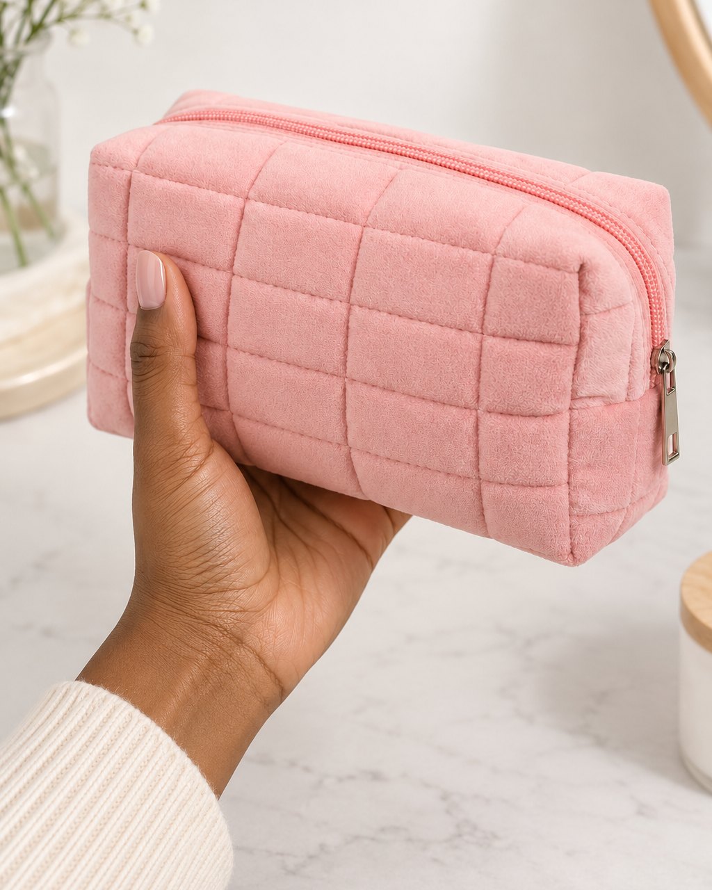 The quilted bag held in one hand, about the length of a phone and a half