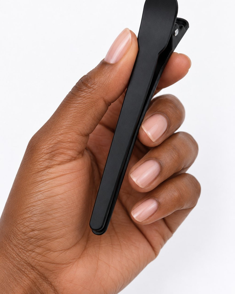 One black clip held between finger and thumb