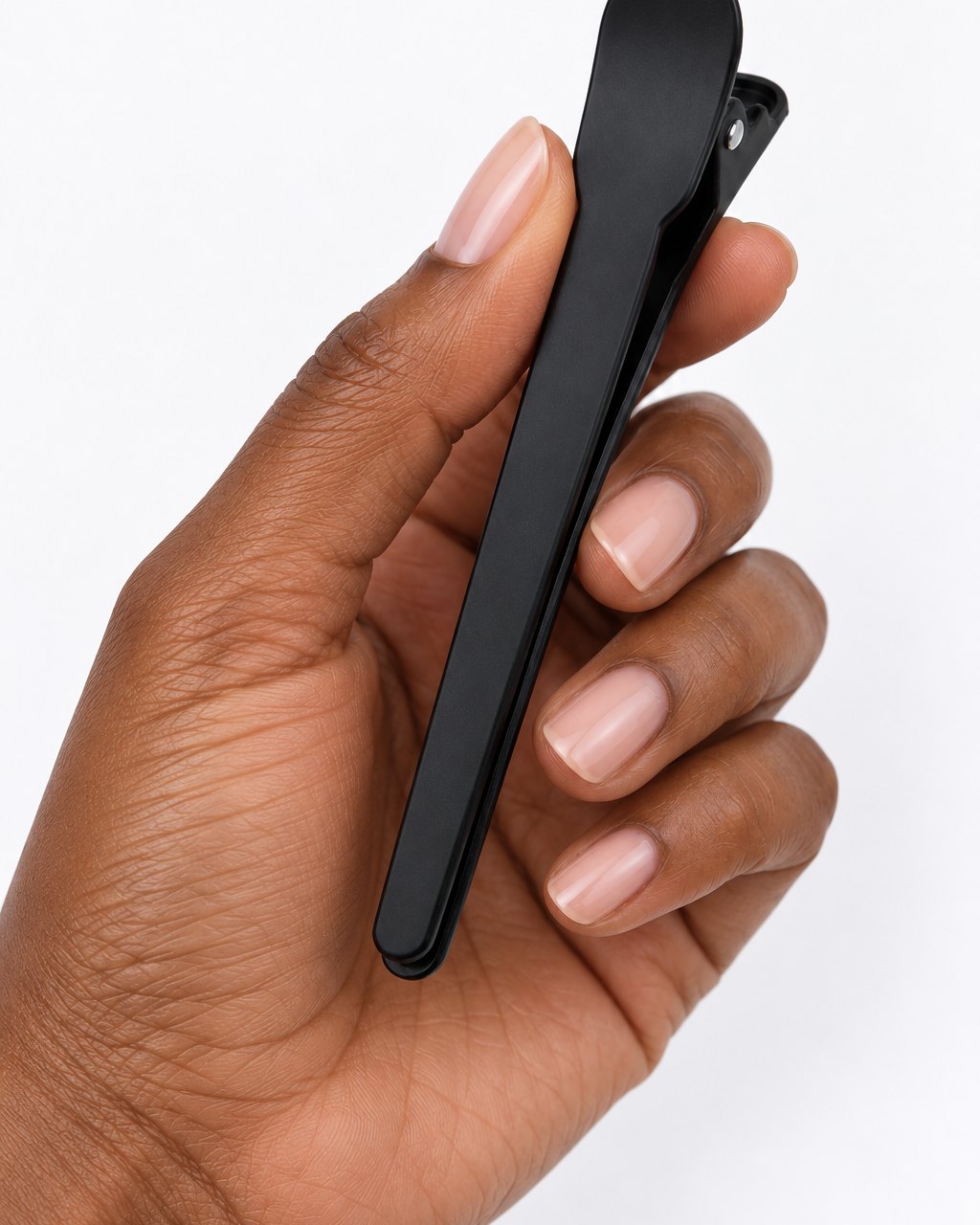 One black clip held between finger and thumb
