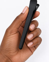 One black clip held between finger and thumb