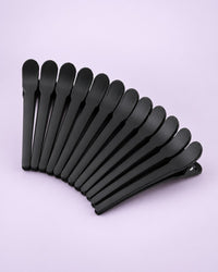 Twelve matte black duckbill sectioning clips fanned out