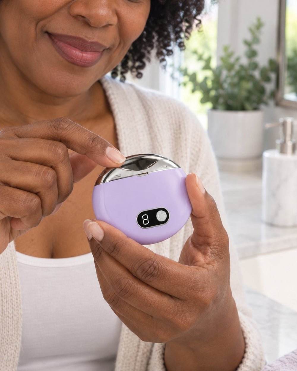 Woman resting a fingernail in the opening of the lilac electric nail clipper