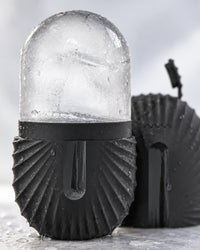 Close-up of the smooth frozen ice dome rising from the ribbed holder