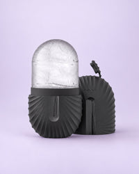 Black ribbed silicone ice capsule holding a clear dome of ice, cap beside it
