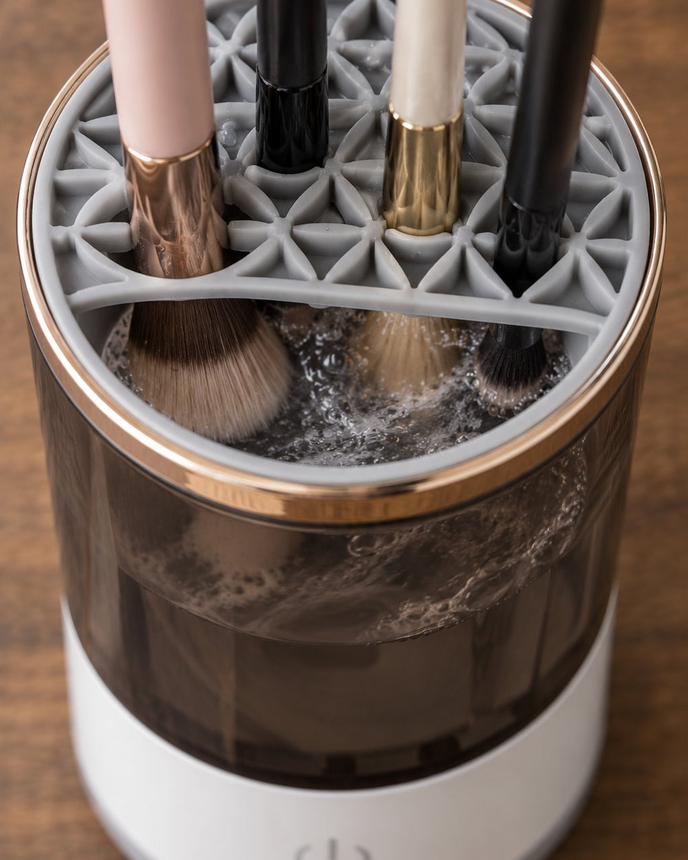 Close-up of the holder lid with several brushes slotted head-down into the jar