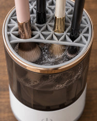 Close-up of the holder lid with several brushes slotted head-down into the jar