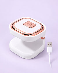 White mini one-finger UV LED nail lamp with rose-gold-tone trim and USB cable