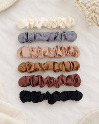 All six scrunchies laid out in a neat row by colour