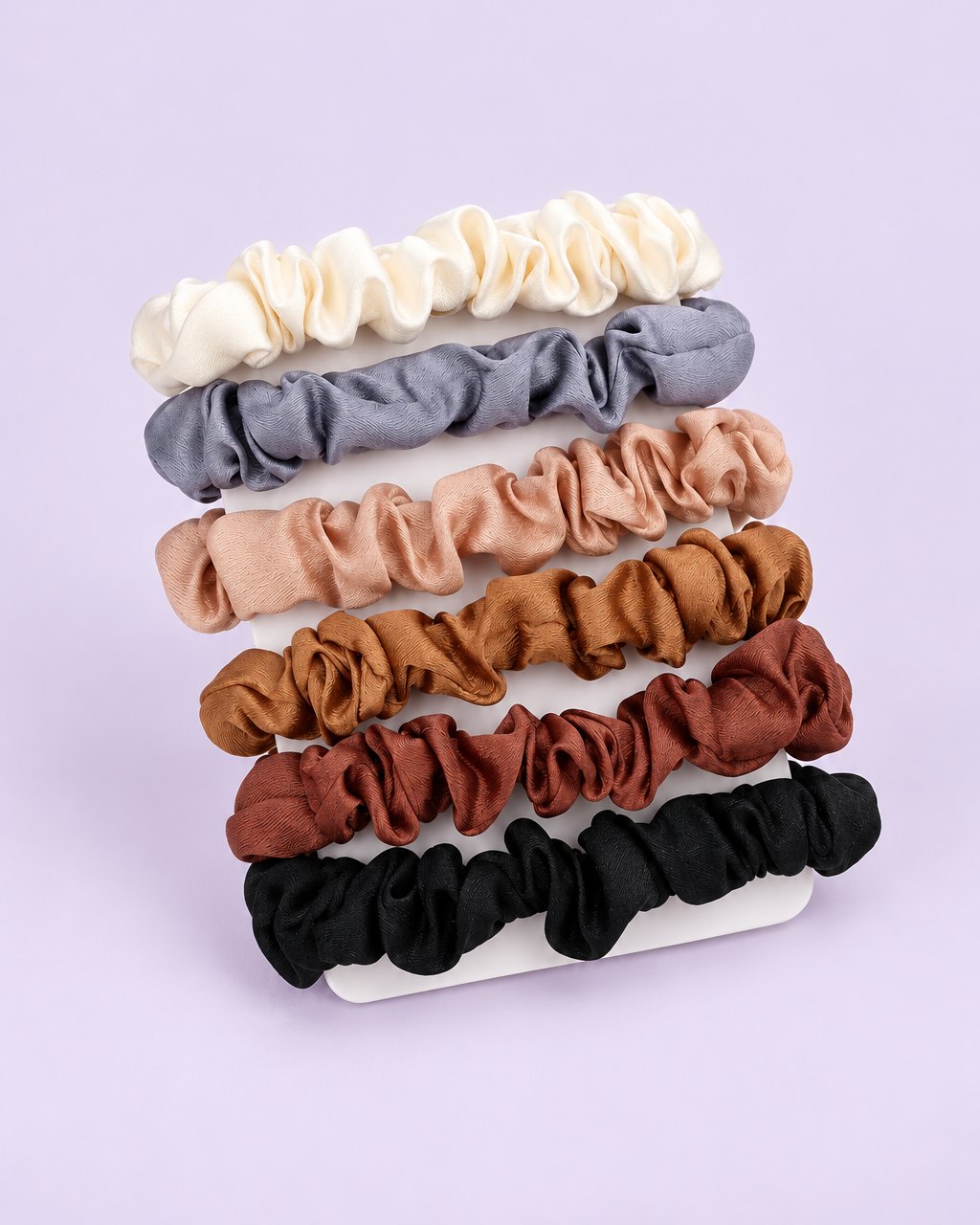 Six skinny satin-finish scrunchies in cream, grey-blue, blush, caramel, mauve and black