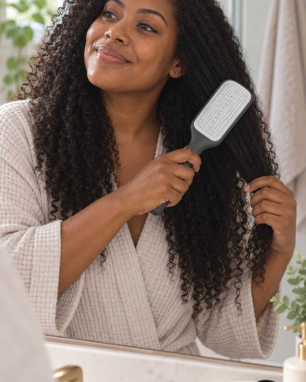Woman brushing through her long hair with the self-cleaning brush