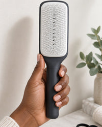 The brush held in one hand, the size of a regular paddle brush