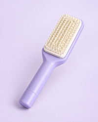 Lilac self-cleaning paddle brush with a white cushioned pad