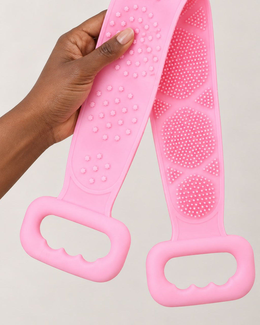 The scrubber strap folded in half in one hand