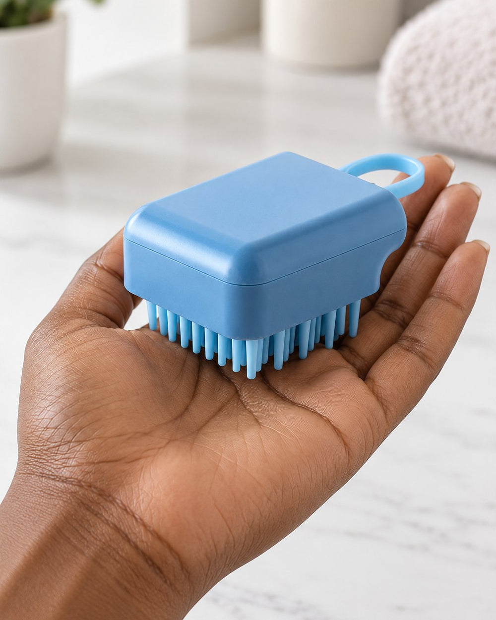 The scalp brush resting in a woman's palm