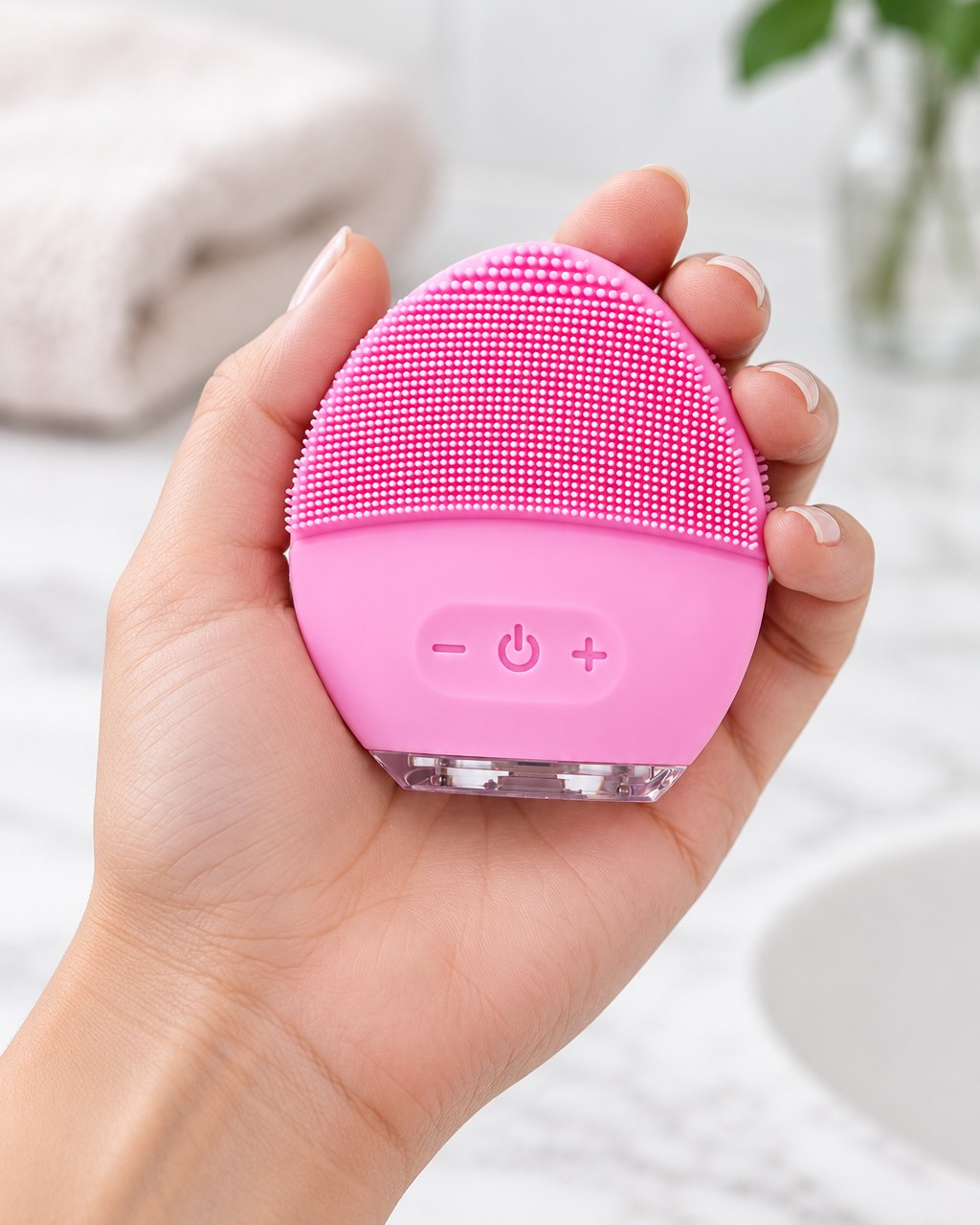 Silicone face brush resting in an open palm, about the size of the palm