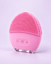 Pink oval silicone face brush with soft nubs and three buttons