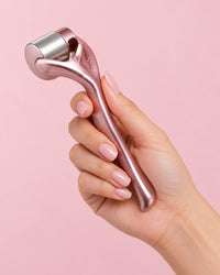 The ice roller held by its curved handle in one hand